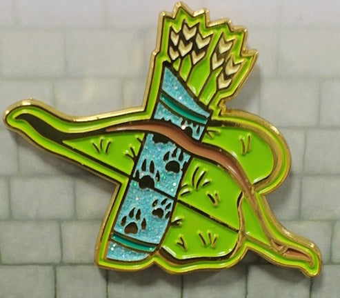 A glittering enamel pin shaped like a Ranger character class emblem, featuring green, teal, gold, and multicolored details.