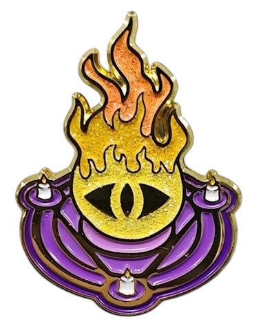 A glittering enamel pin featuring a stylized flame and an eye design in orange and purple colors, representing the Warlock character class.