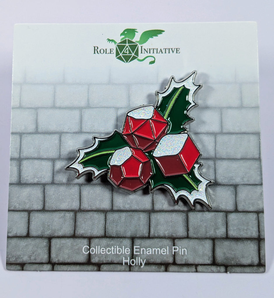 Hard enamel pin beautifully designed to depict a holly leave with snow-covered dice berries. Packaged in a polybag with backing card containing description, SKU, and UPC barcode.
