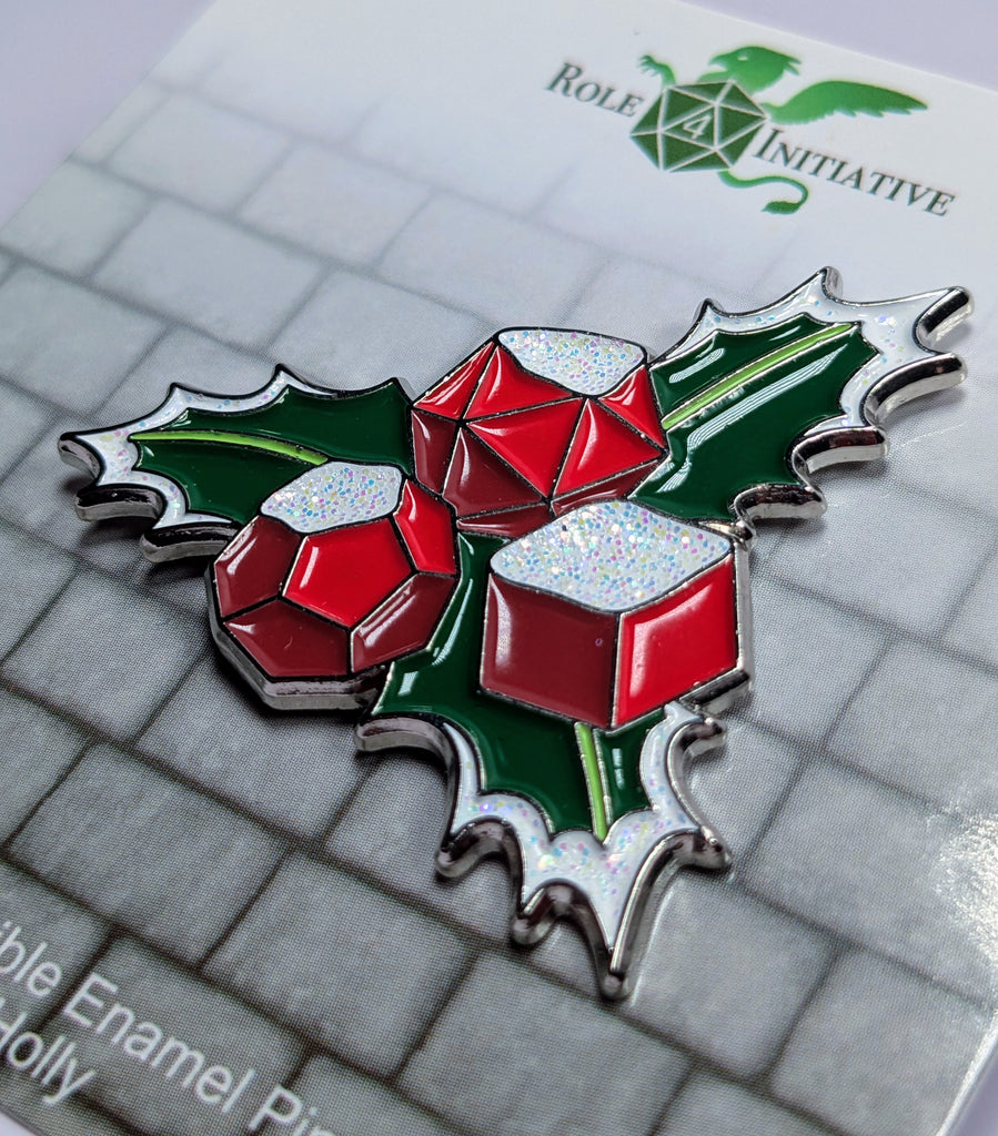 Hard enamel pin beautifully designed to depict a holly leave with snow-covered dice berries. Packaged in a polybag with backing card containing description, SKU, and UPC barcode.