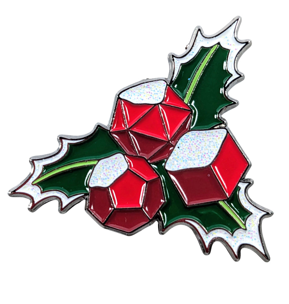 A collectible enamel pin featuring a holly leaf with red and green colors and glitter.