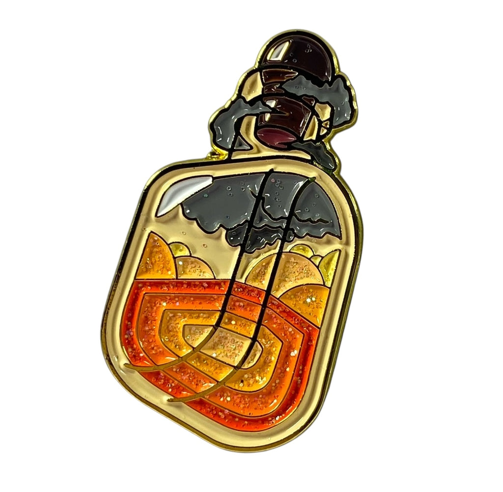 A glittering enamel pin depicting a magmatic potion bottle with orange and dark grey layers, surrounded by swirling black clouds of ash and smoke.