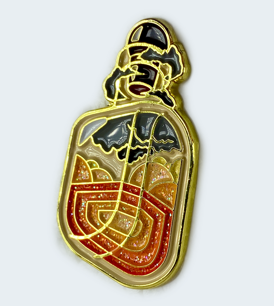 A glittering enamel pin depicting a magmatic potion bottle with orange and dark grey layers, surrounded by swirling black clouds of ash and smoke.