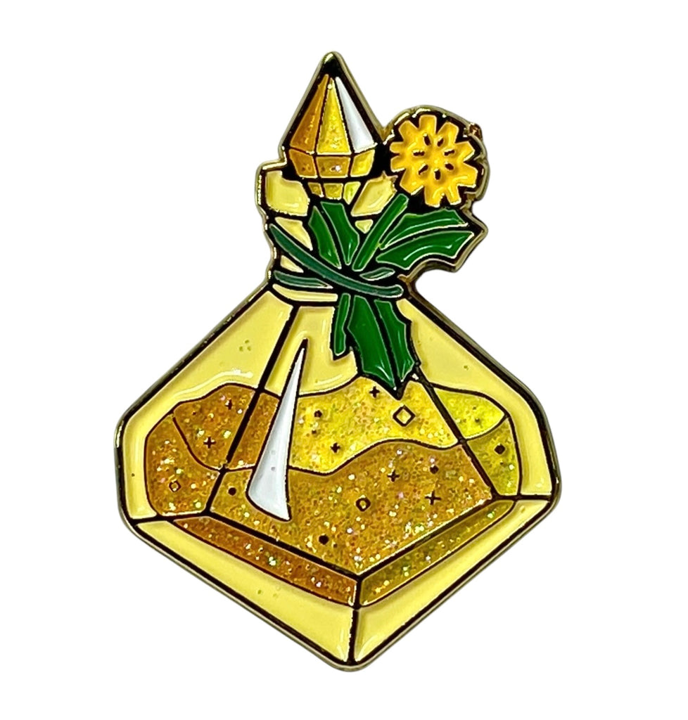 A collectible enamel pin featuring a d10-shaped yellow wish-granting pollen bottle with a dandelion tied to the neck, surrounded by glittery powder.