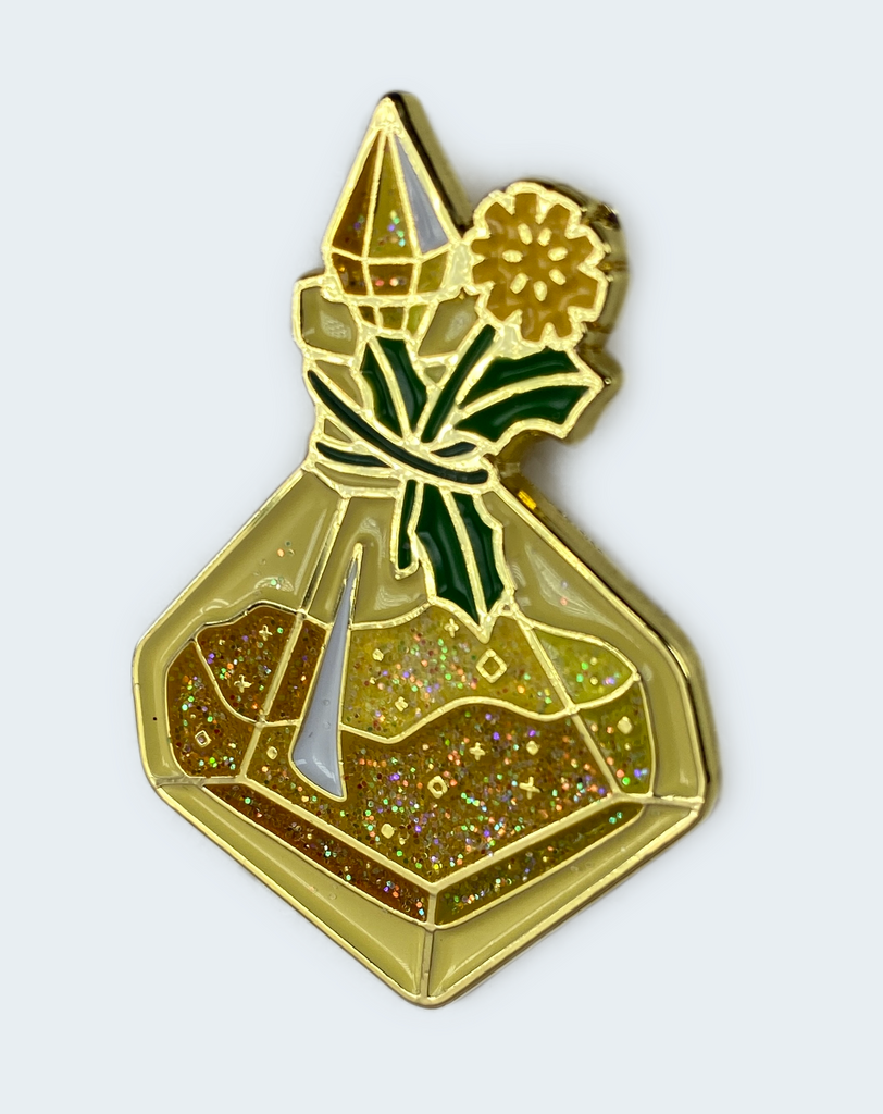 A collectible enamel pin featuring a d10-shaped yellow wish-granting pollen bottle with a dandelion tied to the neck, surrounded by glittery powder.