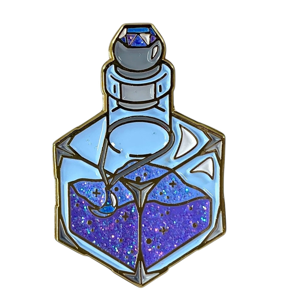 This 1.5"-tall glittering enamel pin depicts a d6-shaped magic dust bottle in crushed blue and indigo hues, with a moon shaped gem pendant hung around the bottle's neck. The vibrant colors are dressed in iridescent glitter in the dust contents, the moon pendant, and the gem encrusted in the stopper.