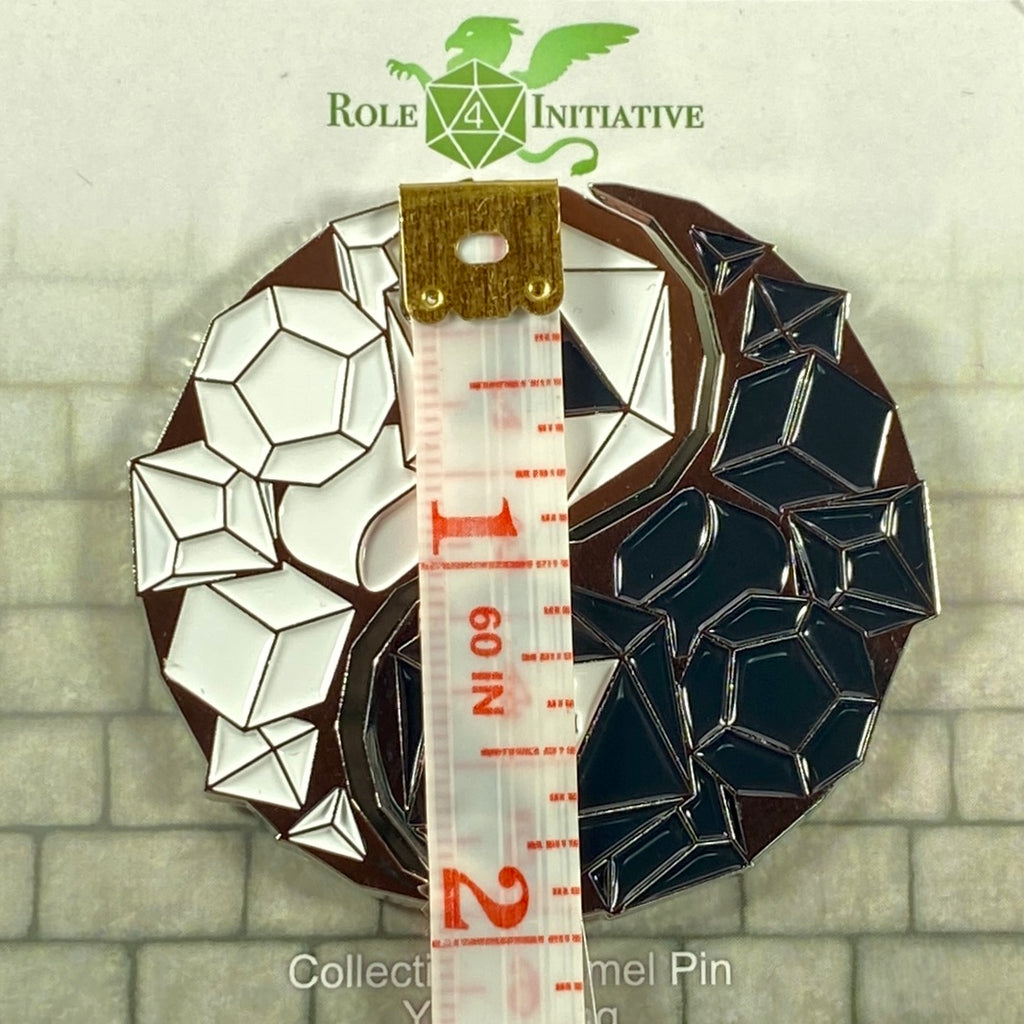 Decorative pin with geometric design and ruler for scale, on a stone wall background with 'Role 4 Initiative' branding.