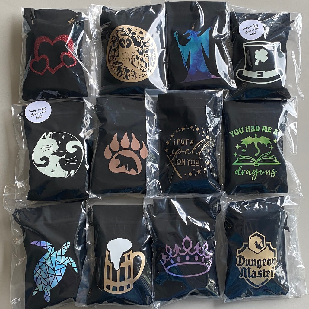 Collection of black velvet 4"x6" bags with various designs in clear poly bag. Some designs glow in the dark.